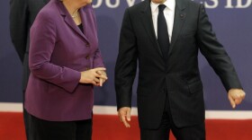 German Chancellor Angela Merkel talks to French President Nicolas Sarkozy on the eve of the G-20 summit in Cannes, France, on Wednesday. The European economic crisis is taking center stage at the summit.