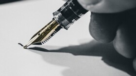 A hand holding a pen on paper.