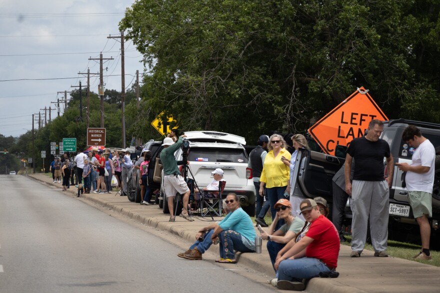 Onlookers await President Donald Trump's arrival in Kerrville on Friday, July 11, 2025.