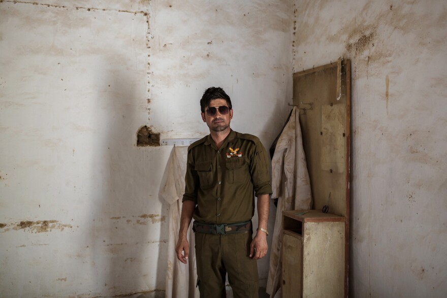 Saeed Murad, the brother of Yazidi activist and Nobel Peace laureate Nadia Murad, in his family home in Kocho, northern Iraq. A white cloak that his mother used to wear hangs in the corner behind him. Murad is one of the few survivors from Kocho. Shot six times by a young ISIS fighter, he was left for dead among the bodies.