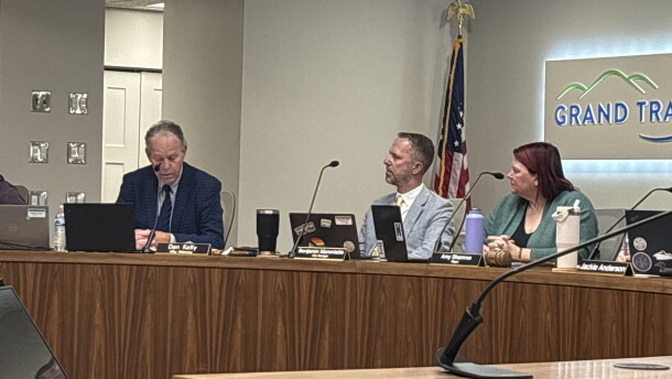 Traverse City city attorney Dan Kelly answers questions about the prowling ordinance in a city commission meeting while seated next to City Manager Benjamin Marentette and Mayor Amy Shamroe. (IPR News / Maxwell Howard)