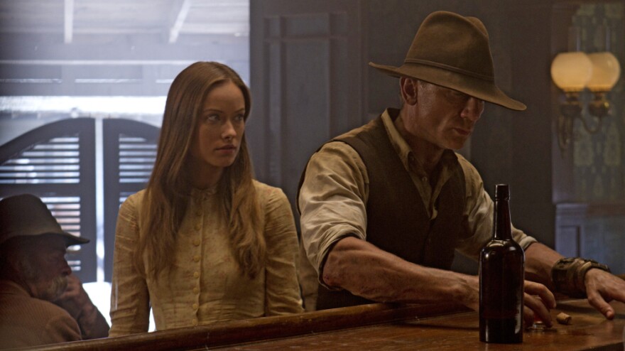 Olivia Wilde stars as an elusive traveler, and Daniel Craig plays a stranger with no memory of his past in the sci-fi Western <em>Cowboys & Aliens</em>.