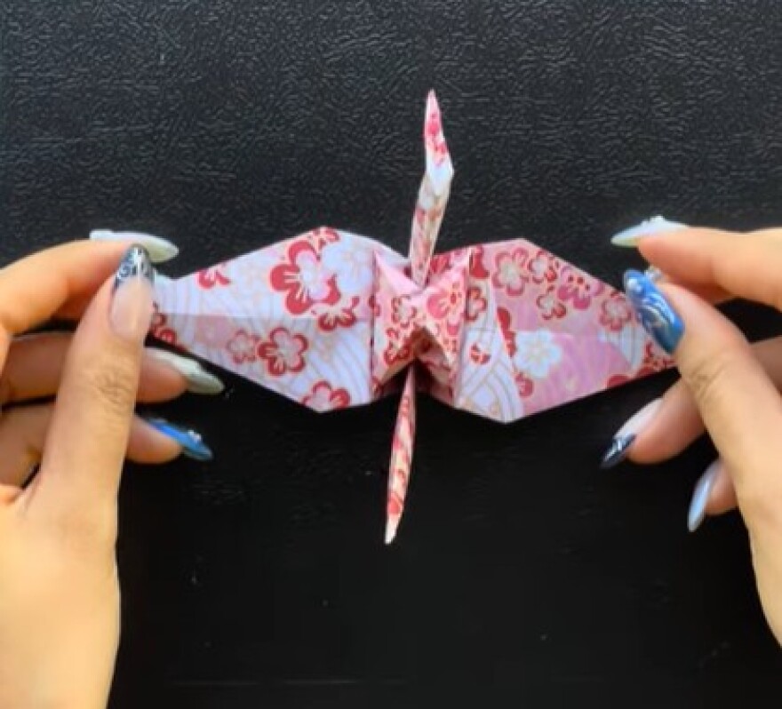 A nearly completed paper crane.