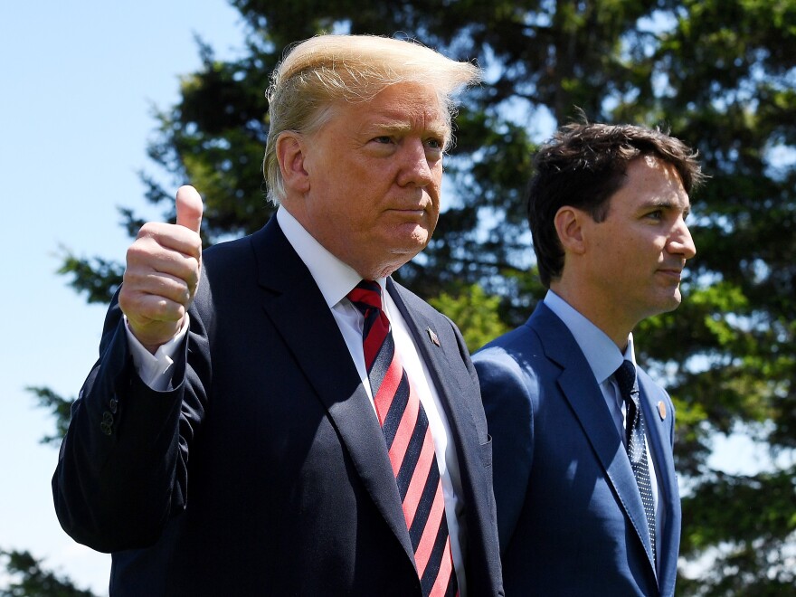 President Trump gives a thumbs up as he is greeted by Canadian Prime Minister Justin Trudeau at the official welcome of a G-7 summit Friday in Quebec City. The summit comes as the U.S. is clashing with Canada and other big trading partners over tariffs.