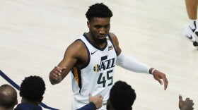 A photo of Donovan Mitchell high fiving teammates. 
