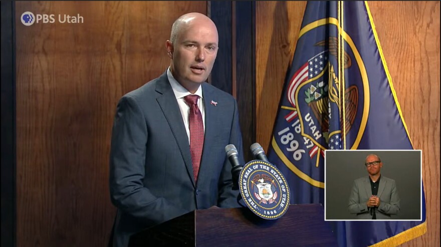 Governor Cox stands at a pulpit for his August press conference