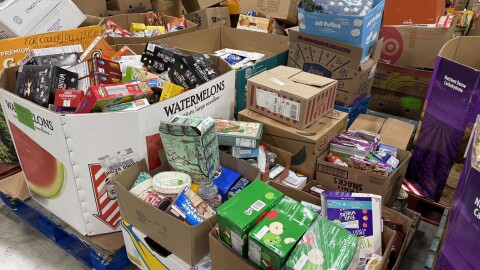 Multiple pallets of food rest on the floor of a warehouse