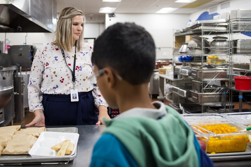 Director of Food Services Caitlin Harrison talks with students as they go through the lunch line at Wisconsin Hills Middle School in Brookfield, Wis., Tuesday, Sept. 20, 2022. Pandemic-induced supply chain issues hit schools hard and dramatically changed what students saw on their plates. “Any supply chain issue, we have seen it,” Harrison says. (Kayla Wolf for Wisconsin Watch)