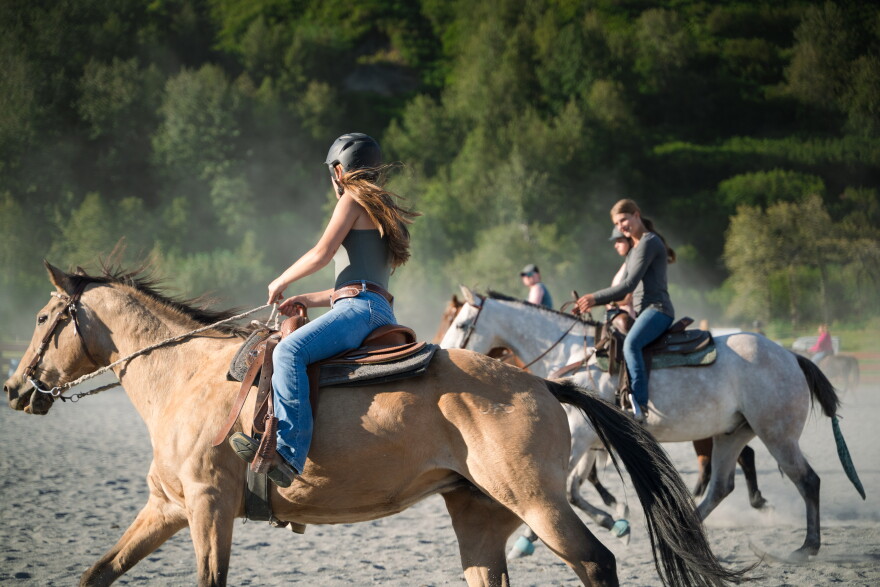 Ailey Hiner (left) rides with Naamah North (right) and others during a drill team practice on Sep. 2