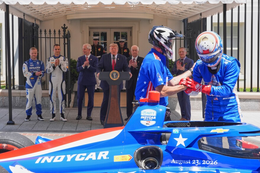 IndyCar Series driver David Malukas, right, exits a race car following a demonstration as Felix Rosenqvist, the 2026 Indy 500 winner, from left, Alex Palou, the reigning IndyCar champion, Bud Denker, Freedom 250 Grand Prix chair and Penske Corp. president, President Donald Trump, Roger Penske, chairperson and founder of Penske Corp., and Fox Sports CEO Eric Shanks watch on West Executive Drive at the White House during a showcase for the upcoming Freedom 250 Grand Prix auto race, Monday, July 13, 2026, in Washington.