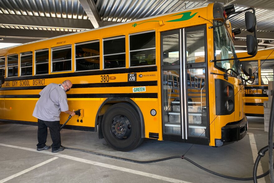 Ken Martinez, transportation director for the Salt Lake City School District, pulls the charger out of one of his eight electric buses, May 31, 2022.