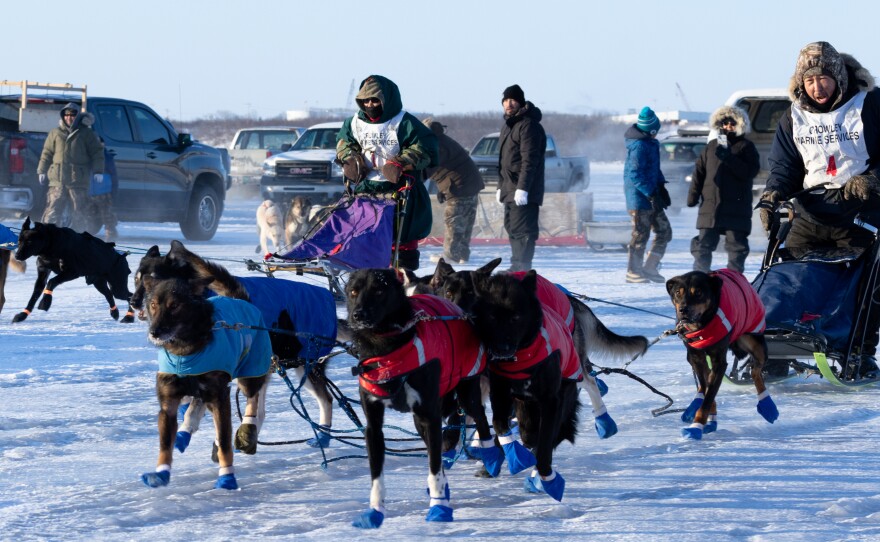 Mushers Maurice Andrews (left) and Aaron Alexie take off in the mass start of the 2024 Akiak Dash on Jan. 27, 2024.