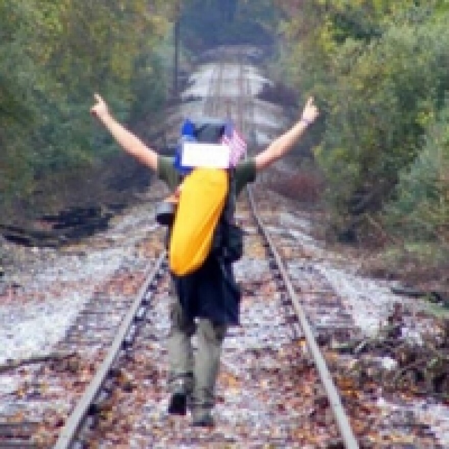 Hiker walking down train tracks