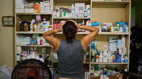 Laura Mendoza, who runs the “Medicine Is Not for Sale” community project, stands in front of a shelf stocked with medicine donated by humanitarian groups for free distribution in Havana, Cuba, Thursday, Oct. 8, 2026.