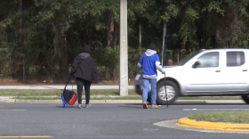 Pedestrians cross Northeast 39th Avenue to get to the bus stop. In the past five years, there have been two fatalities and four serious injuries as pedestrians attempt to cross this road. (Karla Robiana/WUFT News)