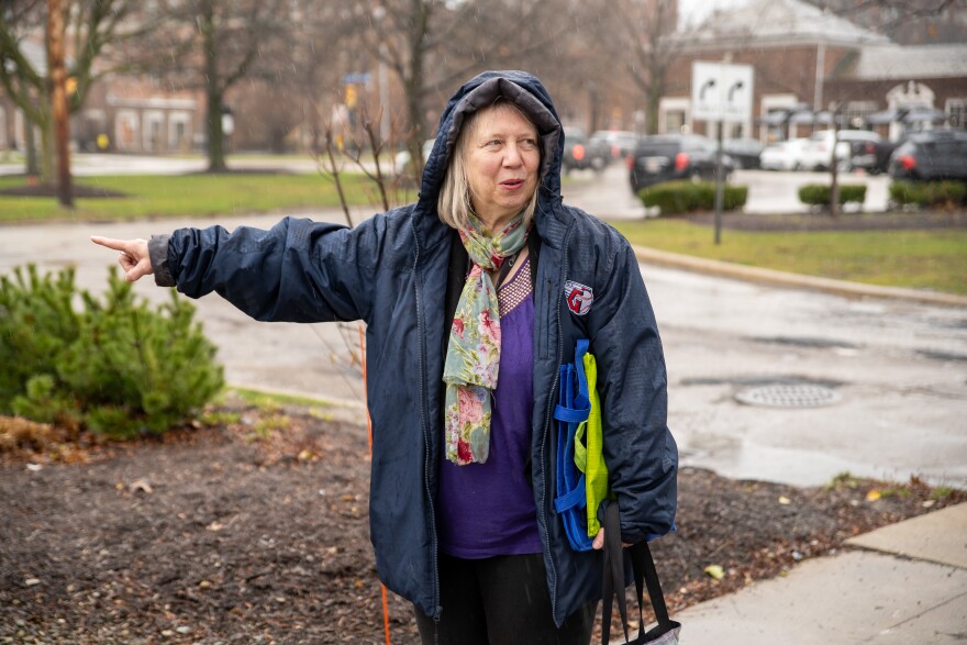 woman stands at Shaker Square pointing at a building off camera