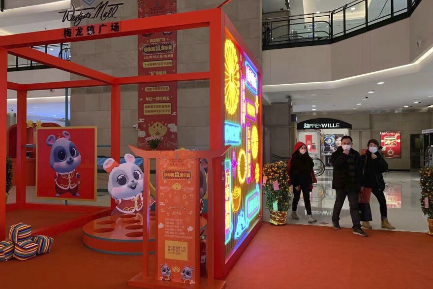 Masked residents walk through a deserted shopping mall in Shanghai on Sunday.