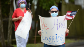 Health care workers at Northbridge Health Care Center in Bridgeport hold signs during a visit by Gov. Ned Lamont and other dignitaries to recognize frontline health care workers, residents and patients in recovery from COVID-19. Northbridge was one of four COVID recovery centers in the state.