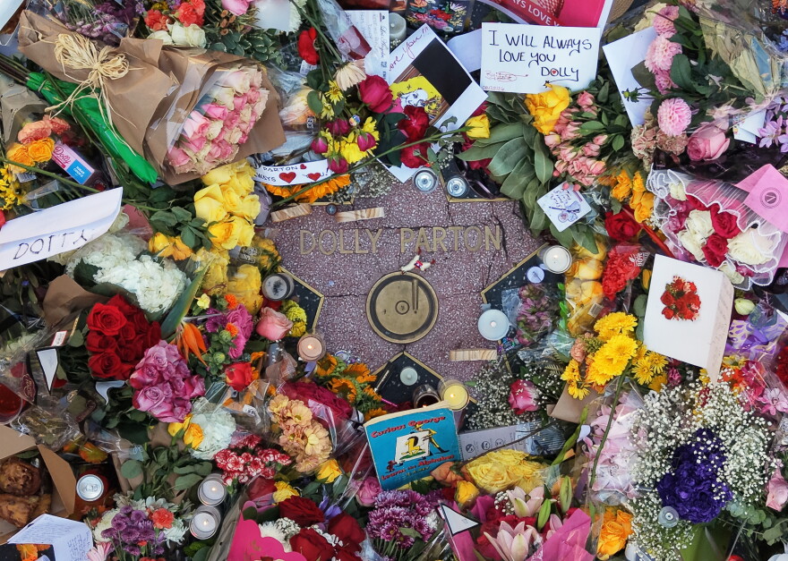 In This aerial view, flowers, notes and photos are left on Dolly Parton's star on the Hollywood Walk of Fame on Wednesday, Aug. 26, 2026, in Los Angeles. (AP Photo/Jae C. Hong)