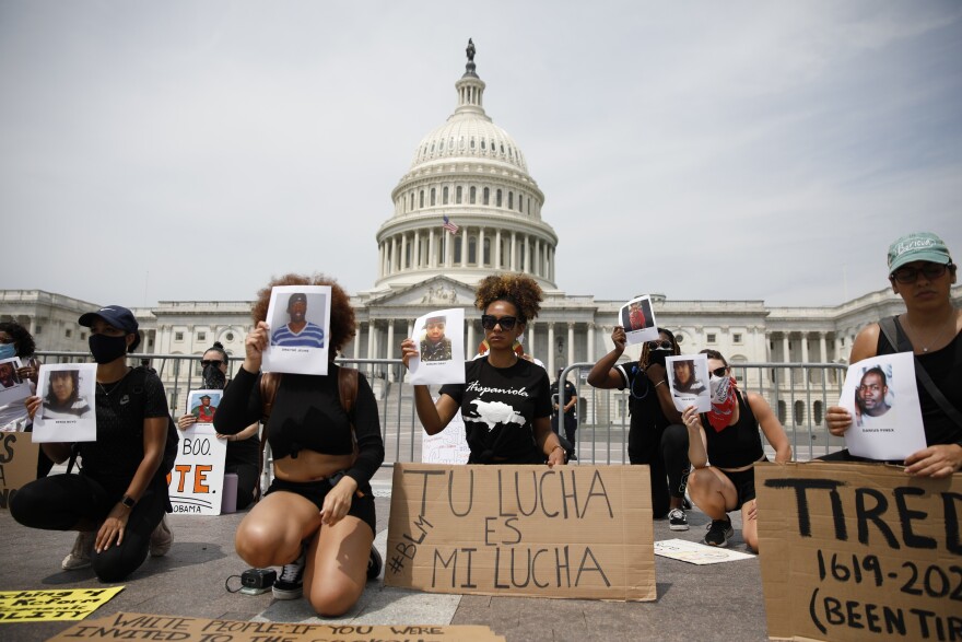 Protesters Heyssis Castillo and Katherine Bonilla (center left and right) demonstrate in front of the Capitol on Saturday.