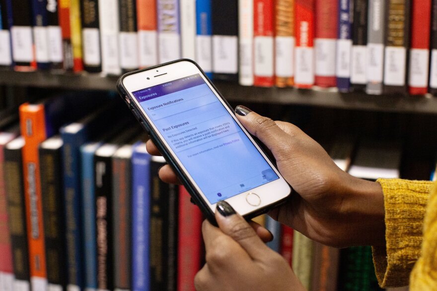 Mohamed checks the COVIDWISE app on her smartphone to detect if she has been exposed to the coronavirus.