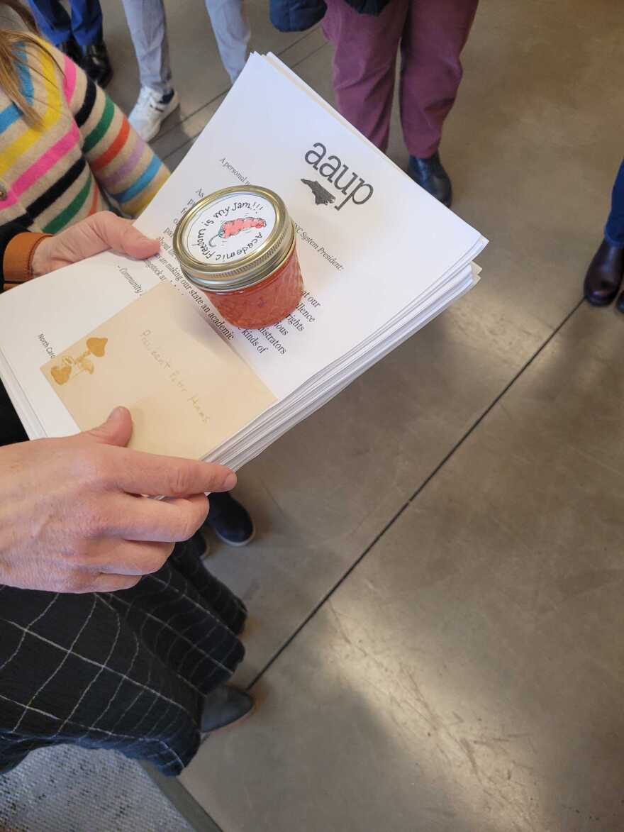 NC AAUP President Belle Boggs holds a 2,700-signature petition and "academic freedom" jelly at the UNC System Office on Dec 12, 2025. Boggs and several other faculty members attempted to deliver the petition to Hans, asking him to reconsider a plan to make all university syllabi public records.