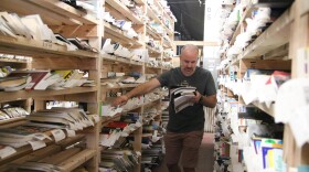 Jacob Pinkerton looks for a book for an order among the shelves in the Aspen Book Company warehouse on August 5, 2025, in Denver, Colo.