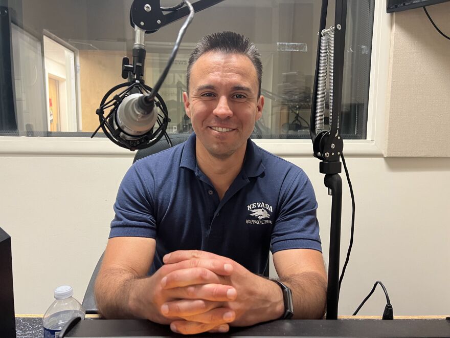 Mike Escobar smiles for a photo inside a sound booth.