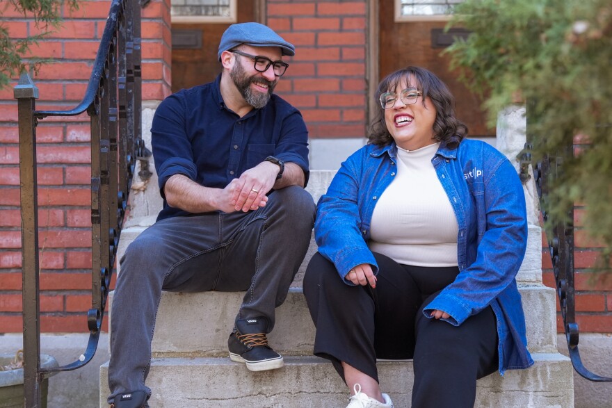 Luis Antonio Perez and Paola Rodriguez sit on a classic Saint Louis stoop amid brick architecture as they have a conversation.