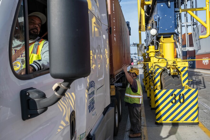 A hydrogen-powered, rubber-tired gantry crane loads a shipping container onto a semi-truck at Yusen Terminals at the Port of Los Angeles in San Pedro on Feb. 11, 2025.