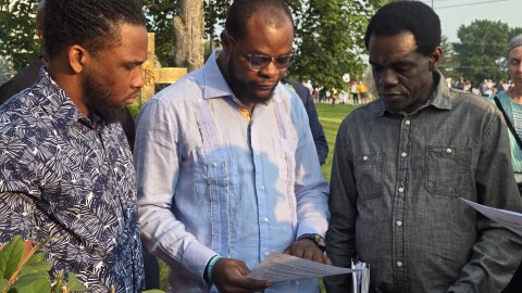 Viles Dorsainvil, executive director of the Springfield Haitian Support Center, goes through paperwork with two men from Haiti ahead of their appointments with ICE Sunday, Aug. 9, 2026.