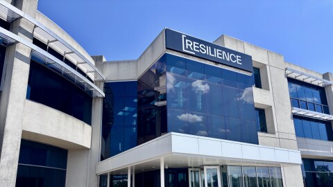 A large building concrete with lots of windows and a word displayed at the very top: Resilience