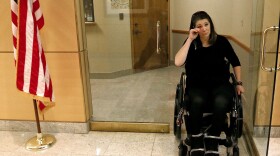 Jennifer Longdon, who survived gun violence but was left a paraplegic, wiped away tears at an April 19, 2013 protest at Arizona Republican Sen. Jeff Flake's Phoenix office.