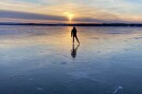 A man skates on Lake Champlain at sunrise. 