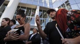 Joe Thomas hugs Elizabeth Reitz, right, during a vigil at City Hall in Las Vegas, Monday, Oct. 2, 2017. The vigil was held in honor of the over 50 people killed and hundreds injured in a mass shooting at an outdoor music concert late Sunday. (Gregory Bull/AP)