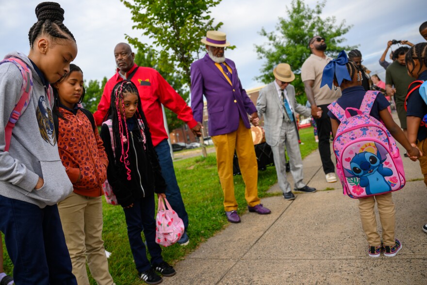 Students at S.A.N.D. School on Main Street in Hartford, gather inside a circle of prayer led by Calling All Brothers before the start of school.