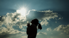 A woman smiles under the sunset. (RunPhoto via Getty Images)