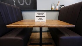 A placard on a restaurant table reminds customers to use social distancing.