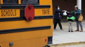 Montgomery County Public Schools Special Needs Bus Attendant Zanashia Rowe helps distribute bags of food donated by Manna Food Center at Quince Orchard High School as part of a program to feed children while schools are closed due to the coronavirus in Gaithersburg, Maryland.