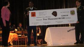 City Mission's Sue Cervi (left) accepts a check from representatives of the Jr. ROTC at McKinley High School.