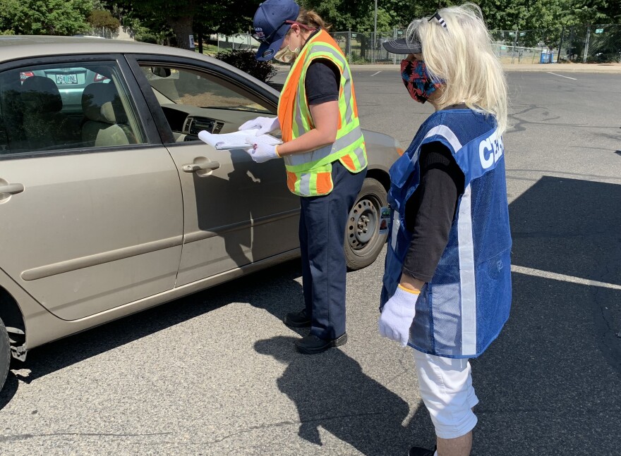 Katie Gibble of Ashland Fire and Rescue consults a list of recipients of free home air purifiers during a giveaway program in Ashland.