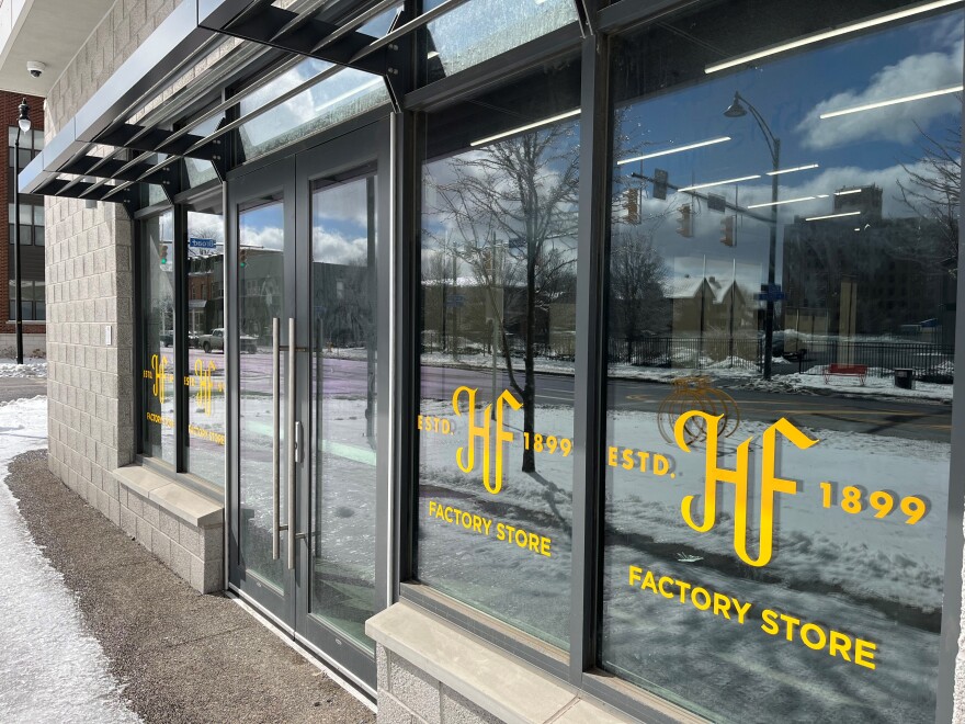 Windows of the Hickey Freeman factory store downtown at East Broad and South Union show the company logo and reads "established 1899" in yellow letters.