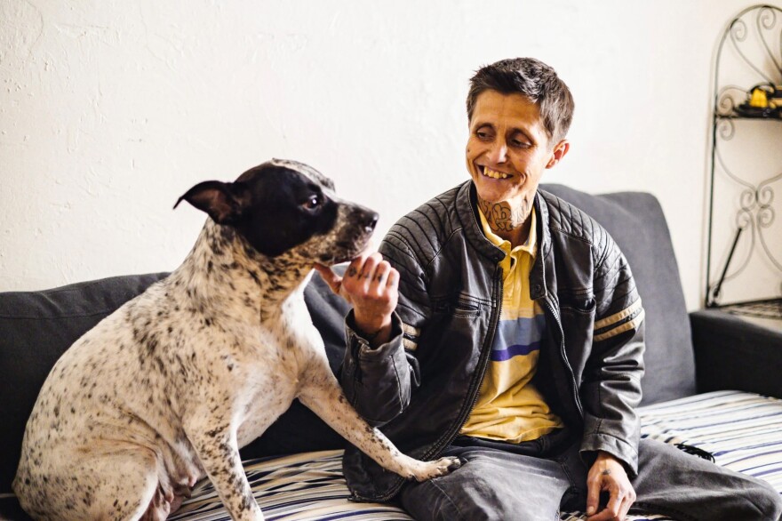 Barbara Grimm sits on her couch with her dog, Sadie Sue, a day before moving out of Pine Lake Apartments.