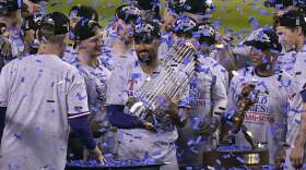 Texas Rangers' Marcus Semien holds the trophy as the Texas Rangers celebrate after winning Game 5 of the baseball World Series against the Arizona Diamondbacks in Phoenix. The Rangers won 5-0 to win the series 4-1. (Gregory Bull/AP)