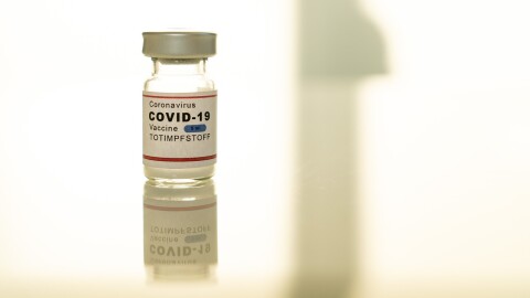 A vial labeled COVID 19 vaccine