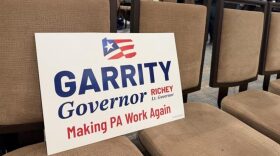 A campaign sign for Republican gubernatorial candidate Stacy Garrity sits against a chair at the state party's Feb. 7, 2026, meeting in Harrisburg.