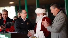 Santa Claus shakes Governor Josh Shapiro's hand after receiving a Certificate of Veterinary Inspection for his reindeer.