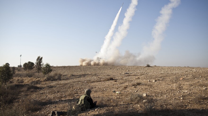 An Israeli soldier lies on the ground as missiles are fired from an Iron Dome anti-missile station on Thursday near the city of Beer Sheva, Israel. The Iron Dome was activated to intercept incoming rockets launched from Gaza.