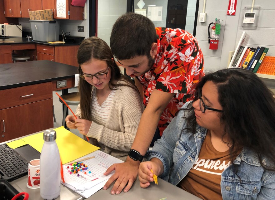 Keith Alyan, center, tutors students in an advanced science class. Alyan is doing A+ even though he wants to go to the University of Kansas, which doesn't honor the Missouri scholarship.