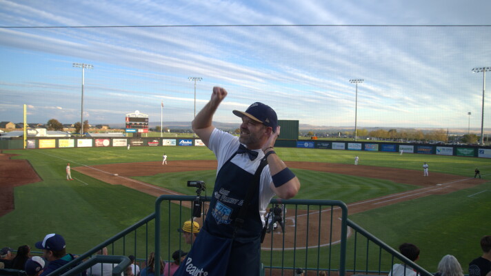 Erik the Peanut Guy in the stands behind home plate at Gesa Stadium pumping up the crowd.